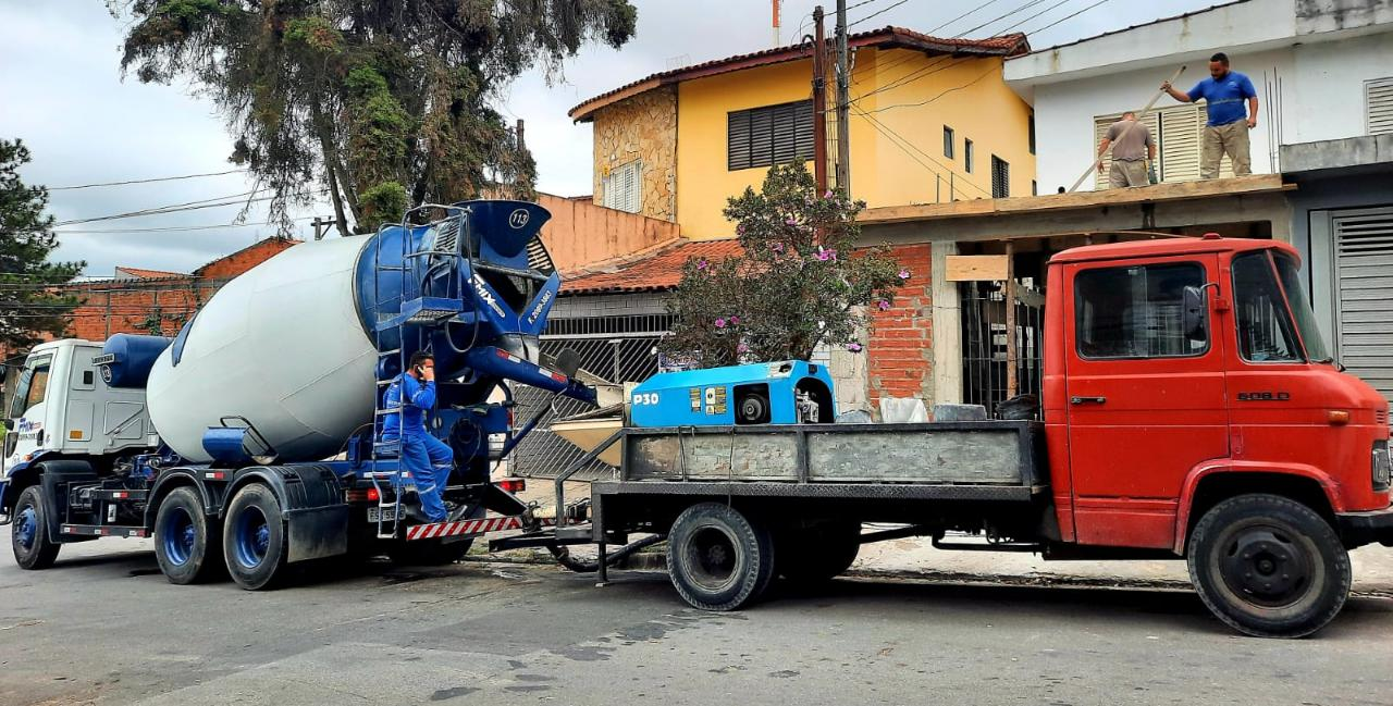 Caminhão betoneira e um caminhão bombeando concreto